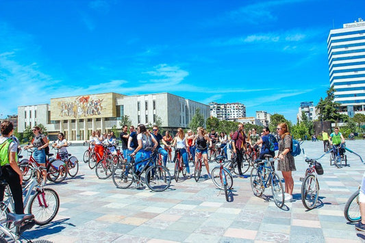 group of tourists cycling the city center of Tirana in Scanderbeg Square for a Guided Bike Tour