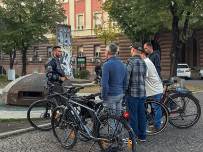 Group of tourists with bicycles while the Guide explains the communist history of Albania bunkers
